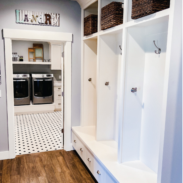Hallway cabinets with baskets and hooks outside the laundry room door of a modern farmhouse Hallway cabinets with baskets and hooks outside the laundry room door of a modern farmhouse