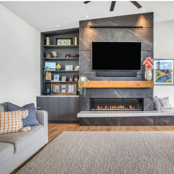 Modern home living room featuring a gray-tiled fireplace with TV built by Riddle Construction Modern home living room featuring a gray-tiled fireplace with TV built by Riddle Construction