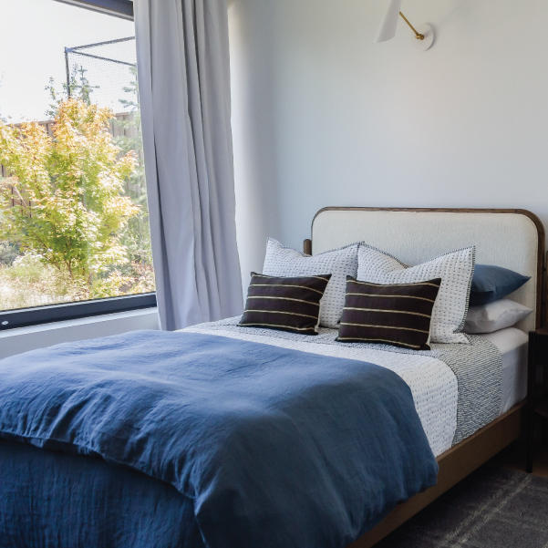 Full-sized bed dressed in bedding for a masculine organic modern style in Lagom built by Riddle Construction Full-sized bed dressed in bedding for a masculine organic modern style in Lagom built by Riddle Construction