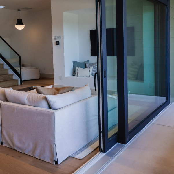 Sliding glass door looking into downstairs media area of the Organic Modern home built by Riddle Construction