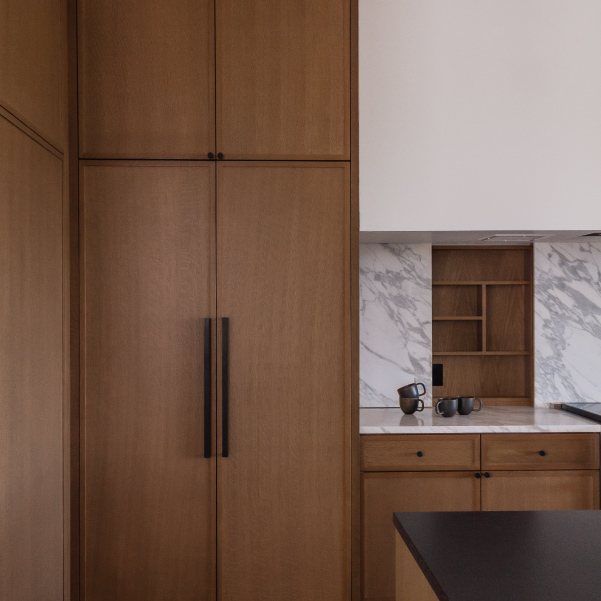A full-size refrigerator faced with cabinet doors in the Lagom home built by Riddle Construction A full-size refrigerator faced with cabinet doors in the Lagom home built by Riddle Construction