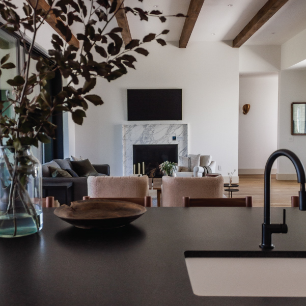 Kitchen view of a marble fireplace and living area in an organic modern home built by Riddle Construction Organic Modern
