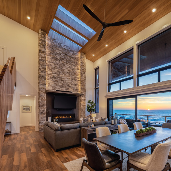 Sunset view from the kitchen into the dining and living area of a custom Oregon Coast home built by Riddle Construction Sunset view from the kitchen into the dining and living area of a custom Oregon Coast home built by Riddle Construction