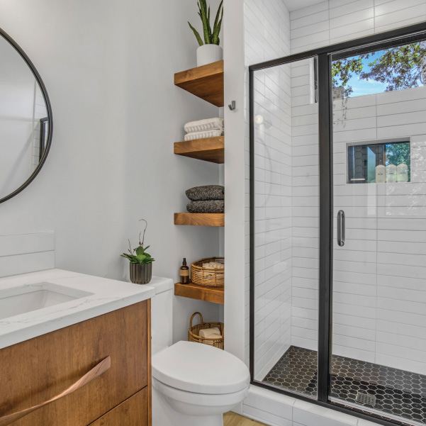 Tiled walk-in closet with wood shelves holding plants and towels in a custom home built by Riddle Construction Tiled walk-in closet with wood shelves holding plants and towels in a custom home built by Riddle Construction