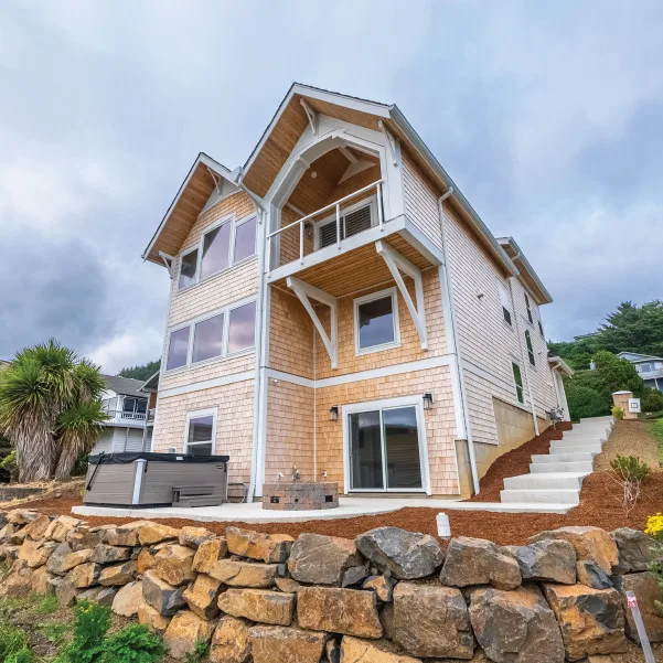 Looking up at a multi-level Oregon Coastal cottage with cedar shakes Coastal Capri Cottage