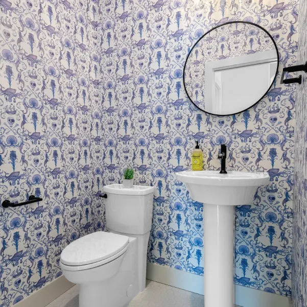 Blue and white powder room with pedestal sinks and oval mirror Blue and white powder room with pedestal sinks and oval mirror