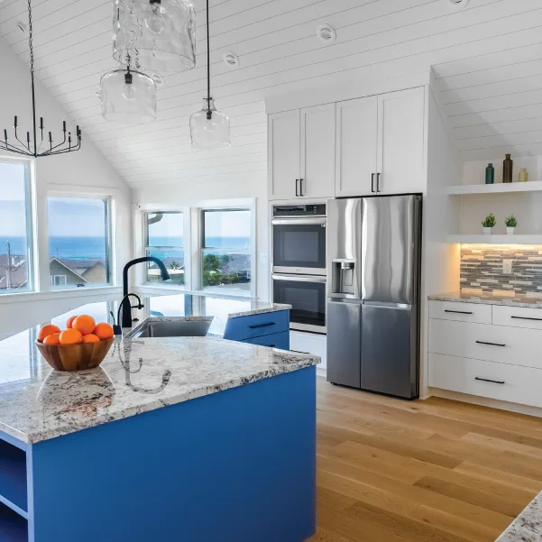 Large kitchen island with blue cabinets and windows with an ocean view Large kitchen island with blue cabinets and windows with an ocean view