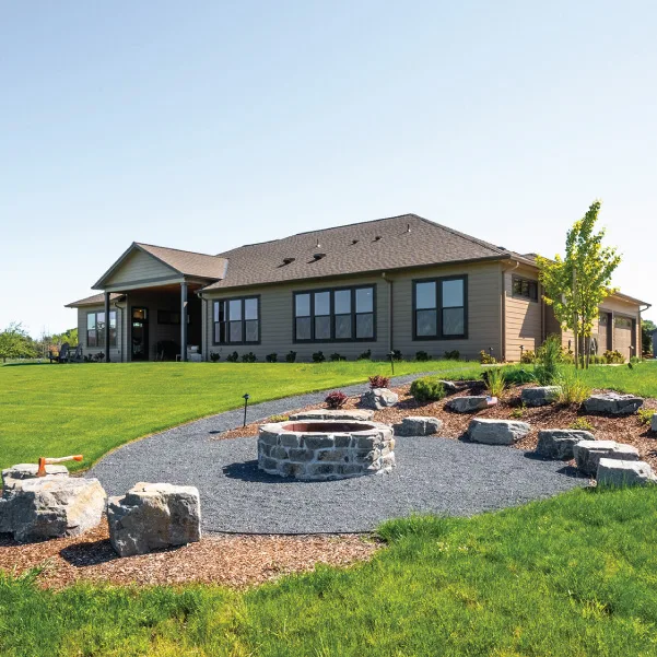 View over an outdoor firepit to a custom ranch built by Riddle Construction View over an outdoor firepit to a custom ranch built by Riddle Construction