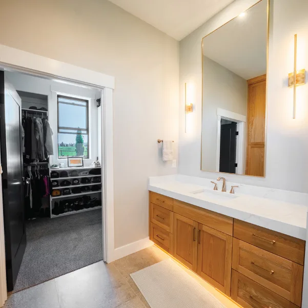Single sink vanity in bathroom leading to a private dressing room Single sink vanity in bathroom leading to a private dressing room
