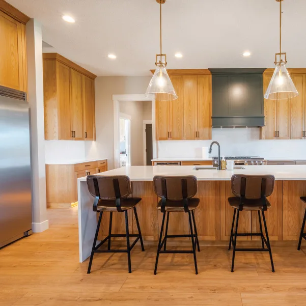 Three chairs at a kitchen island with stainless steel refrigerator Three chairs at a kitchen island with stainless steel refrigerator