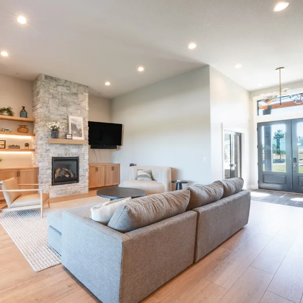 Gray couch facing a built-in fireplace with stone surround Gray couch facing a built-in fireplace with stone surround
