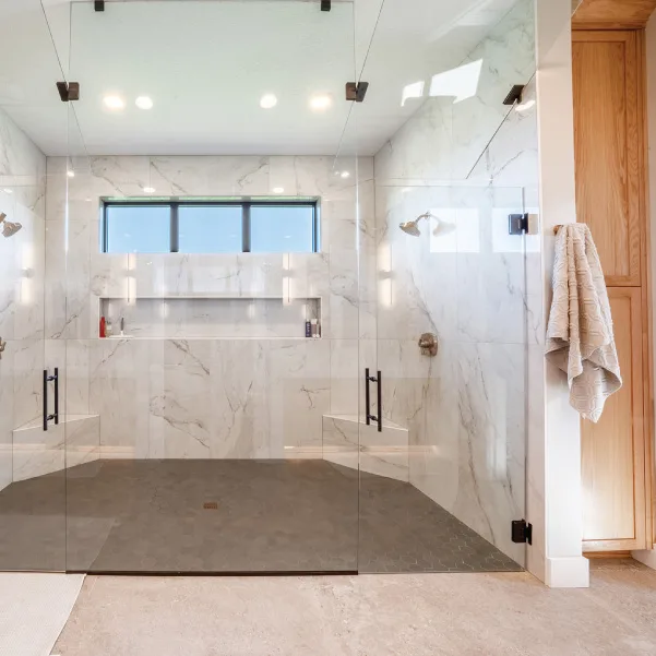 Walk-in tile shower with glass doors and multiple shower heads Walk-in tile shower with glass doors and multiple shower heads